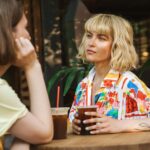 Two young women talking at a coffee shop