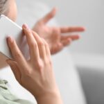 Over shoulder of woman facing away from camera making a phone call