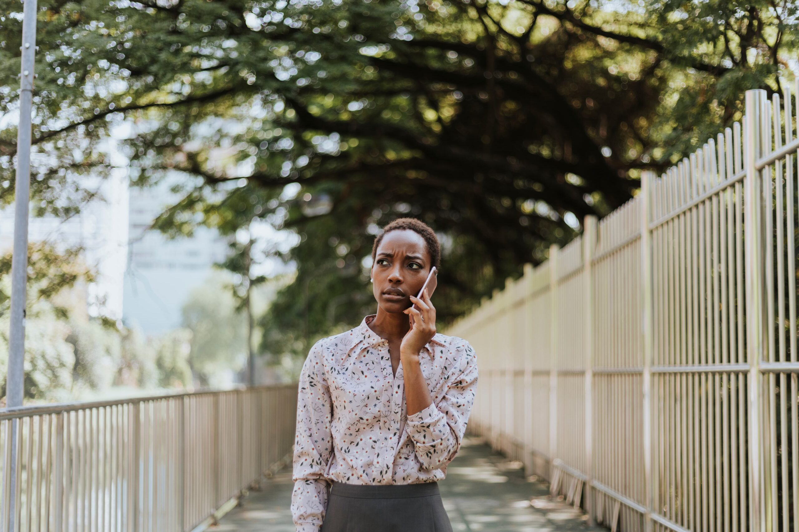 Young woman walking in an urban area while making a phone call looking focused